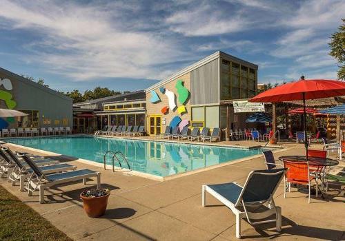 Outdoor pool with lounge chairs and colorful umbrellas at 港威塔 at Packer Park